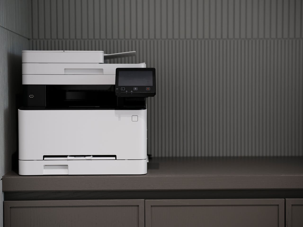 home-hero A sleek, modern printer situated on a minimalist office desk with a textured background.